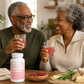 older couple enjoying pressure balance capsules while sitting at the kitchen table smiling
